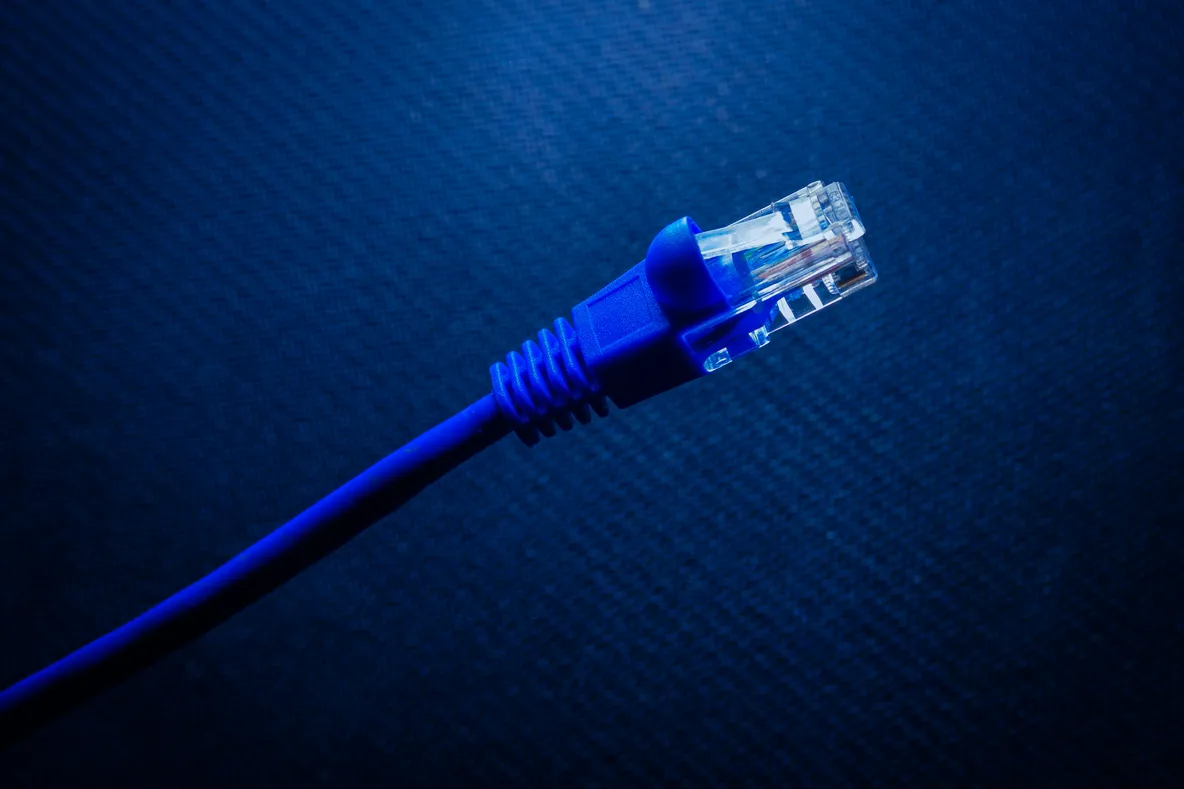 Câble Ethernet RJ45 bleu sur fond de circuit imprimé numérique symbolisant la connectivité réseau